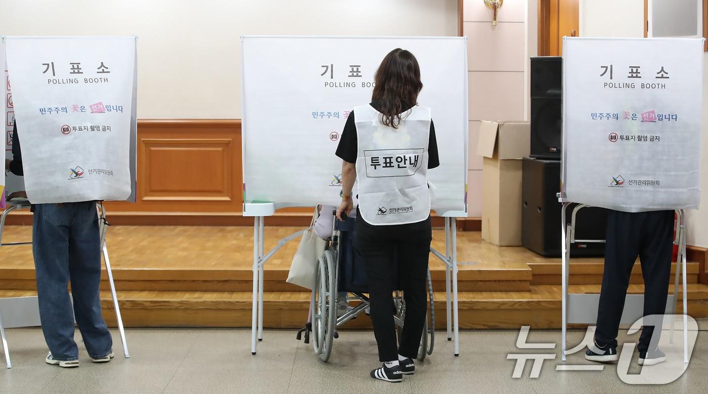 본문 이미지 - 제9회 전국동시지방선거 사전투표 첫날인 29일 대구의 한 사전투표소에서 휠체어를 탄 유권자가 투표사무원(가운데)의 도움을 받아 기표하고 있다. 2026.5.29 ⓒ 뉴스1 공정식 기자