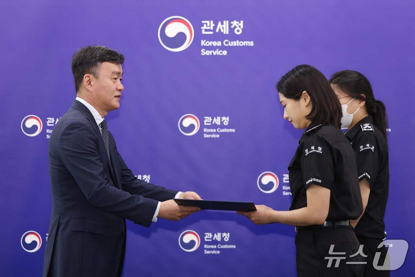 본문 이미지 - 이종욱관세청장(왼쪽)이 마약류 2차 저지선에서 마약을 적발한 세관직원들에게 특별성과 포상금을 지급하고 있다.(관세청 제공.재판매 및 DB금지)/뉴스1