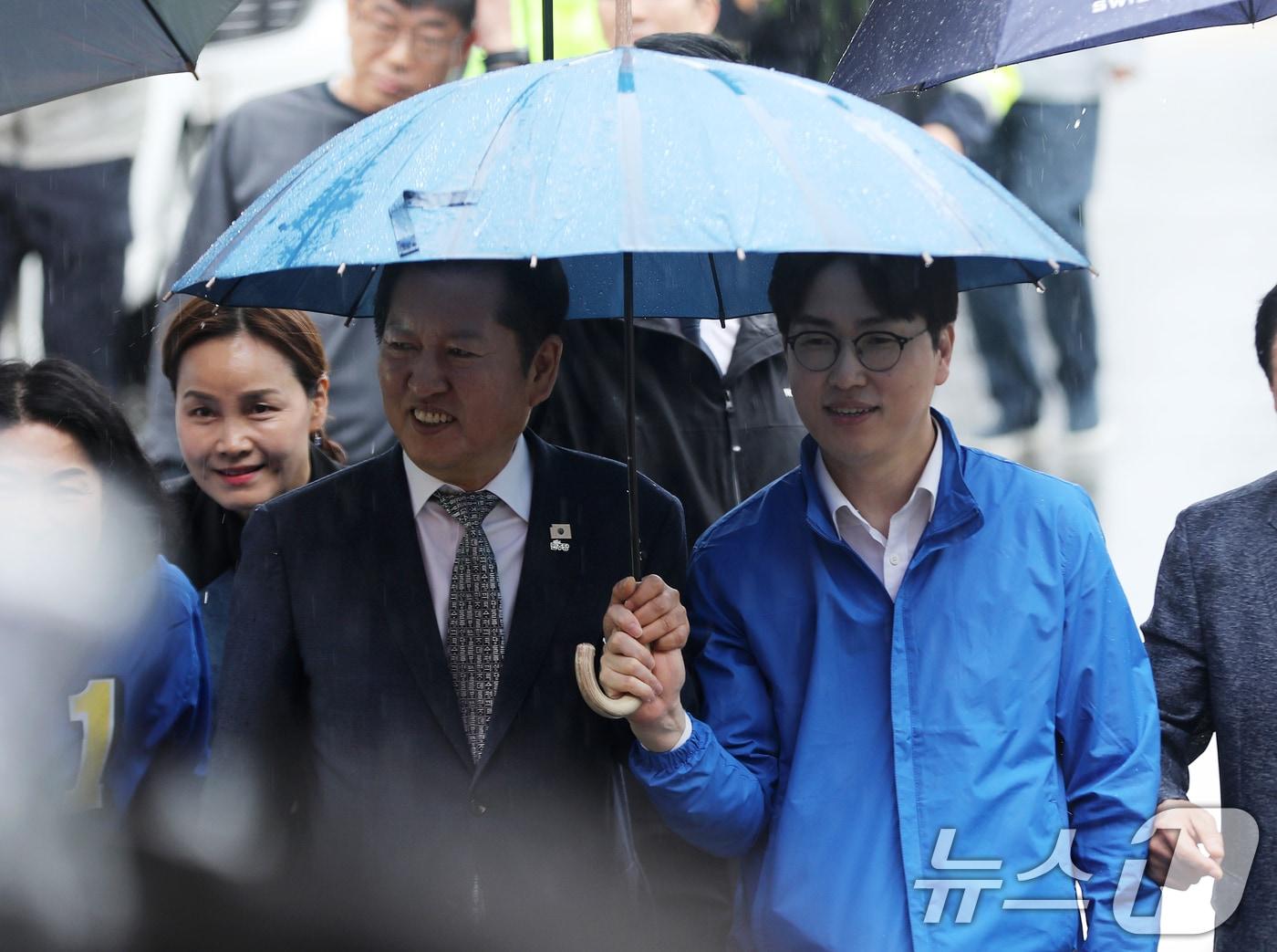 본문 이미지 - 정청래 더불어민주당 대표와 부산 북갑 국회의원 보궐선거에 출마하는 하정우 전 청와대 AI미래기획수석이 3일 함께 우산을 쓰고 부산 북구 구포시장으로 이동하고 있다. 2026.5.3 ⓒ 뉴스1 윤일지 기자