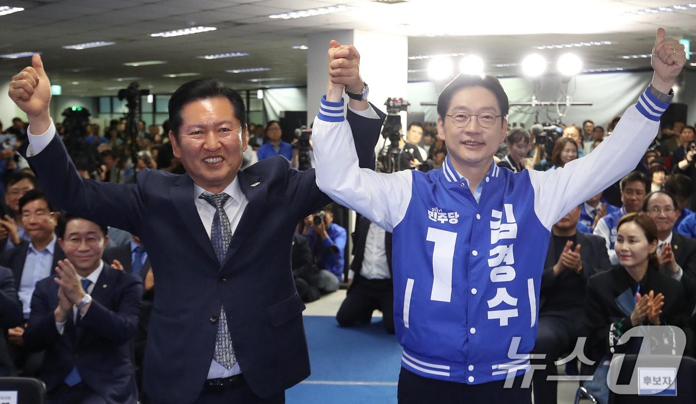 본문 이미지 - 정청래 더불어민주당 대표와 김경수 경남지사 후보가 3일 오후 경남 창원 성산구 김 후보의 선거사무소 개소식에서 손을 맞잡아 들어 올리고 있다. 2026.5.3 ⓒ 뉴스1 윤일지 기자