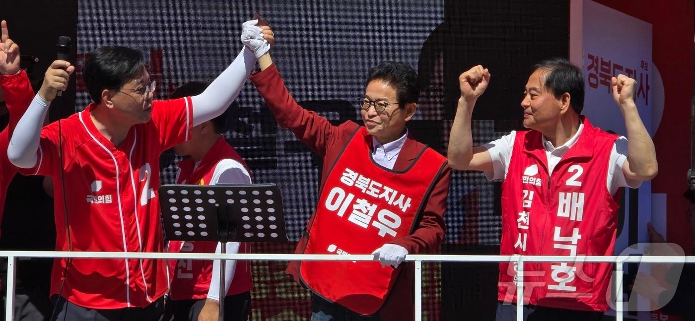 본문 이미지 - 송언석 국힘 원내대표(왼쪽 첫번째)가 30일 경북 김천에서 열린 합동유세에서 이철우 경북지사 후보(가운데). 배낙호 김천시장 후보와 손을 들어 환호에 답하고 있다. ⓒ 뉴스1 정우용 기자