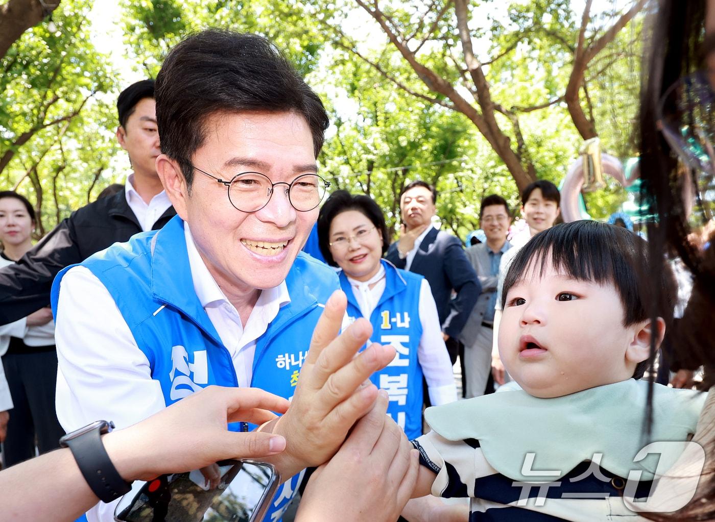 본문 이미지 - 정원오 더불어민주당 서울시장 후보가 30일 서울 성동구 서울숲을 찾아 아기와 인사를 나누고 있다. 2026.5.30 ⓒ 뉴스1 이호윤 기자