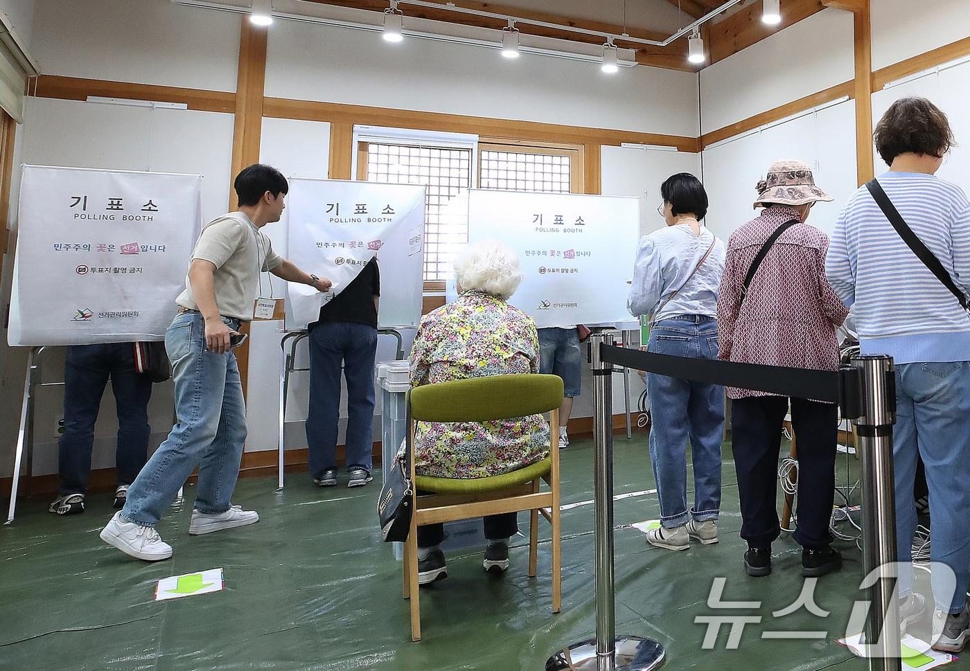 본문 이미지 - 제9회 전국동시지방선거 사전투표 둘째 날인 30일 대구 중구 복합문화공간 하누리어울림센터에 마련된 남산2동 사전투표소에서 투표사무원이 기표소 내부가 보이지 않도록 커튼으로 가려주고 있다. 2026.5.30 ⓒ 뉴스1 공정식 기자