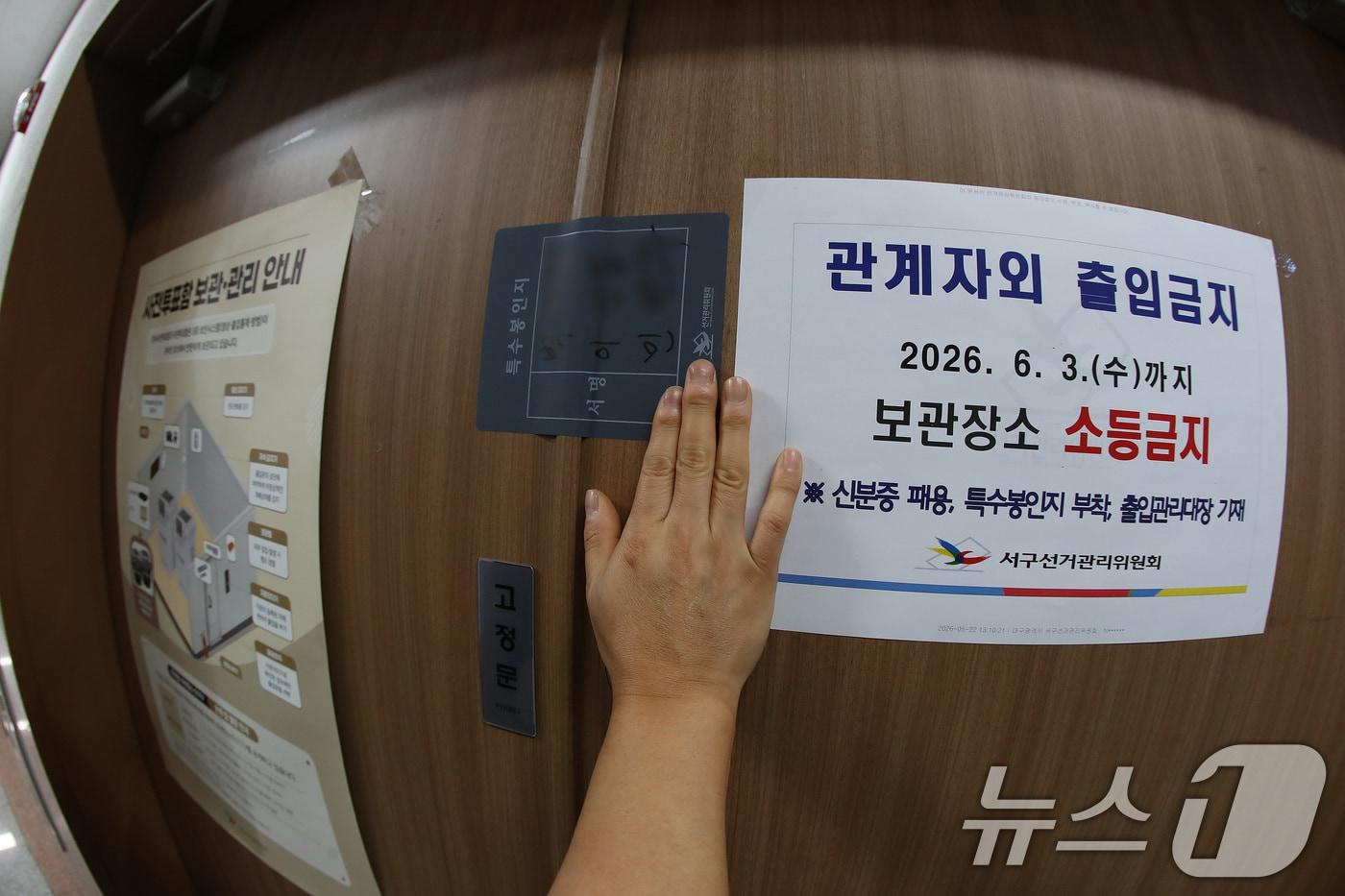 본문 이미지 - 대구경찰청은 3일 실시되는 지방선거와 관련해 개표가 종료될 때까지 최고 수준의 비상근무 체제인 '갑호비상'을 발령해 선거 경비 총력 대응에 나선다.  사전투표가 종료된 지난달 30일 대구 서구선거관리위원회에서 선관위 관계자가 관내사전투표함 보관장소 출입문을 특수봉인지로 봉인하는 모습. (사진은 기사 내용과 무관함) 2026.5.30 ⓒ 뉴스1 공정식 기자