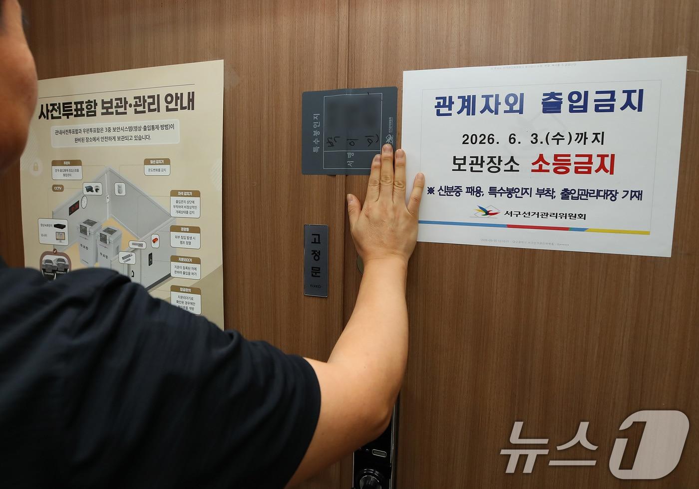 본문 이미지 - 제9회 전국동시지방선거 사전투표가 종료된 30일 오후 대구 서구선거관리위원회에서 선관위 관계자가 관내사전투표함 보관장소 출입문을 특수봉인지로 봉인하고 있다.  2026.5.30 ⓒ 뉴스1 공정식 기자