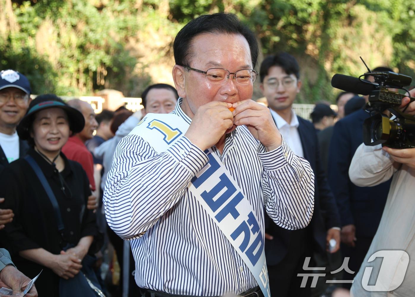 본문 이미지 - 김부겸 더불어민주당 대구시장 후보가 31일 오전 대구 중구 달성공원 새벽시장을 찾아 시식용 오렌지를 맛보고 있다. 2026.5.31 ⓒ 뉴스1 공정식 기자