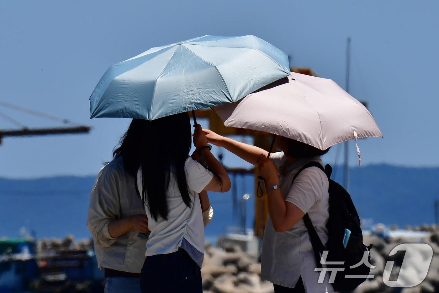 본문 이미지 - 31일 오후 경북 포항시 북구 영일대해수욕장에서 관광객들이 뜨거운 햇볕을 피해 양산을 쓰고 있다. 2026.5.31 ⓒ 뉴스1 최창호 기자