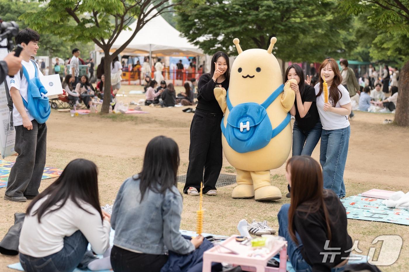 본문 이미지 - 2일 서울 여의도 한강공원 멀티프라자에서 서울시 공공행사와 연계해 열린 ‘르르르 X 책읽는 한강공원, 르르르의 시티뚜어’ 행사에 참여한 르르르와 시민들.(현대차 제공)