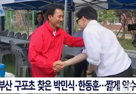 본문 이미지 - 지난 4월 26일 부산 구포초등학교 동창회 행사에서 마주친 국민이힘 박민식 후보와 무소속 한동훈 후보가  악수를 하고 있는 모습. ( SNS 갈무리) ⓒ 뉴스1 