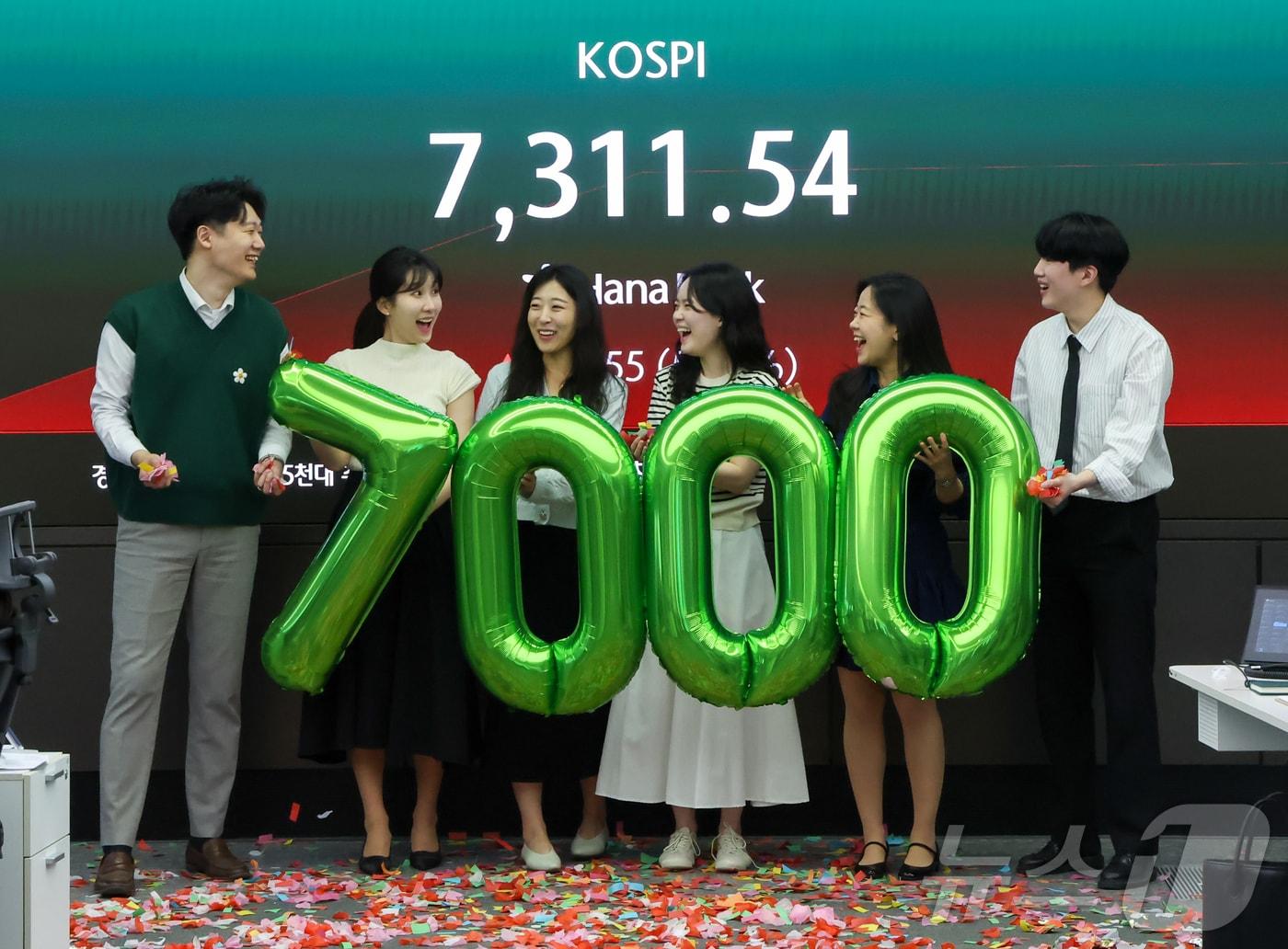 본문 이미지 - 코스피가 장중 7000포인트를 돌파한 6일 서울 중구 하나은행 딜링룸에서 직원들이 축하 세리머니를 하고 있다. 2026.5.6 ⓒ 뉴스1 이종수 인턴기자