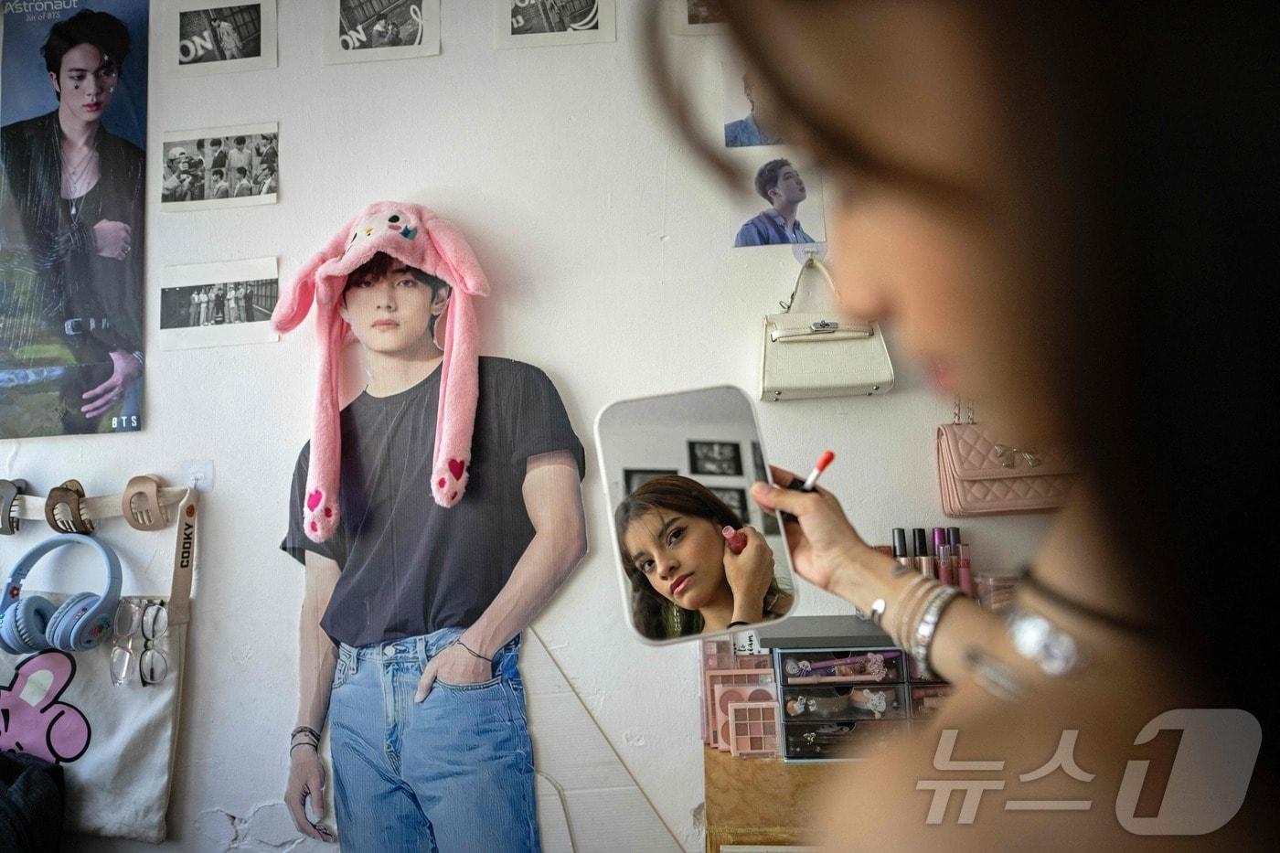 본문 이미지 - 멕시코의 BTS 팬 아나 캄포스 로드리게스가 지난달 29일(현지시간) 멕시코시티 자택에서 BTS 멤버 뷔(V·김태형)의 등신대 옆에서 메이크업하고 있다. BTS는 오는 7일과 9일, 10일 멕시코시티에서 월드투어 공연을 한다. 2026.5.5 ⓒ AFP=뉴스1 ⓒ AFP=뉴스1