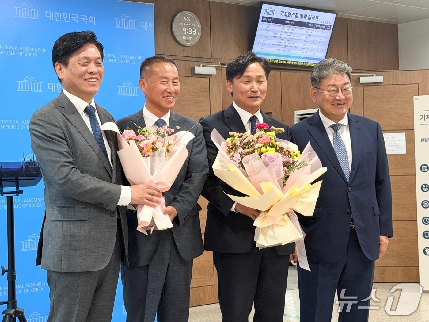 본문 이미지 - 조승래 더불어민주당 사무총장(왼쪽)이 6일 국회 소통관에서 국민의힘을 탈당하고 민주당에 입당한 김왕규 강원도의원(왼쪽에서 두번째)에게 꽃다발을 전달하고 있다. 김 도의원은 민주당 후보로 강원 양구군수 선거에 출마한다. 2026.5.6 ⓒ 뉴스1 김세정 기자
