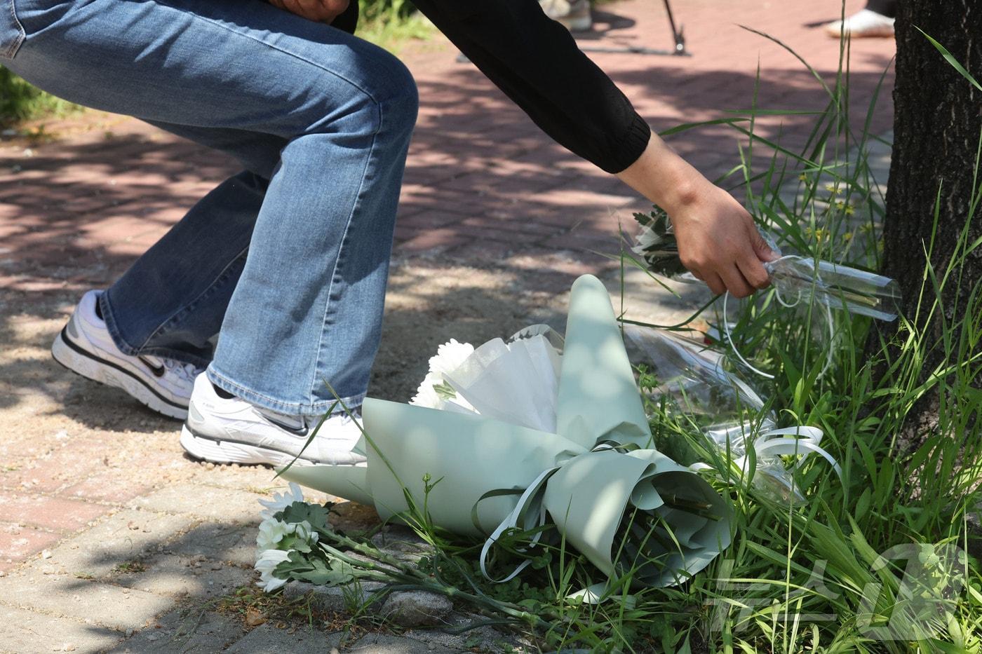 본문 이미지 - 6일 오전 광주 광산구 남부대 인근 피습 현장을 찾은 한 시민이 국화꽃을 내려놓으며 고인의 넋을 기리고 있다. 2026.5.6 ⓒ 뉴스1 조수민 수습기자