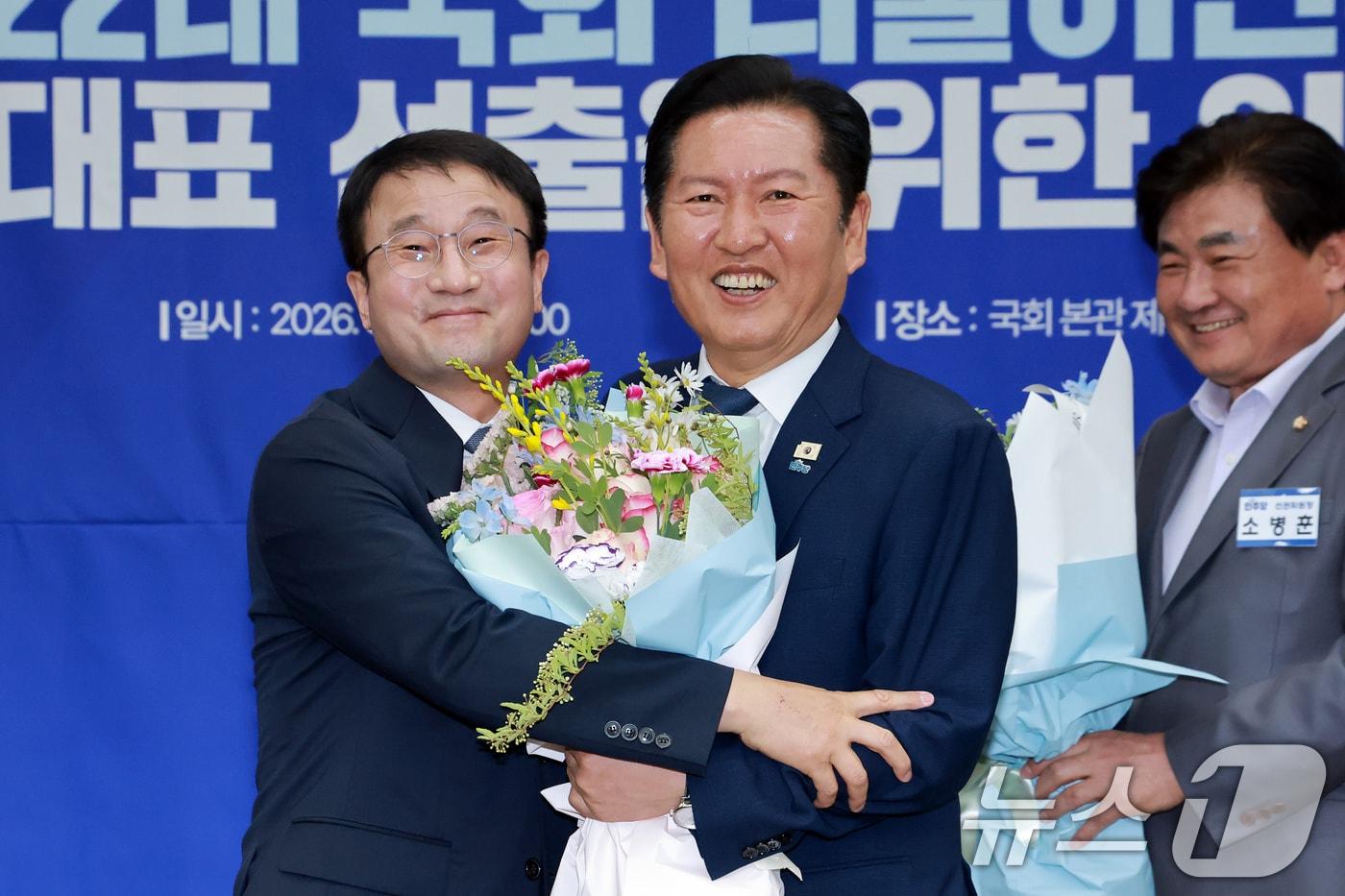 본문 이미지 - 더불어민주당 원내대표로 선출된 한병도 의원과 정청래 대표가 6일 서울 여의도 국회에서 열린 원내대표 선출을 위한 의원총회에서 기념 촬영을 하고 있다. 오른쪽은 소병훈 선거관리위원장. (공동취재) 2026.5.6 ⓒ 뉴스1 유승관 기자