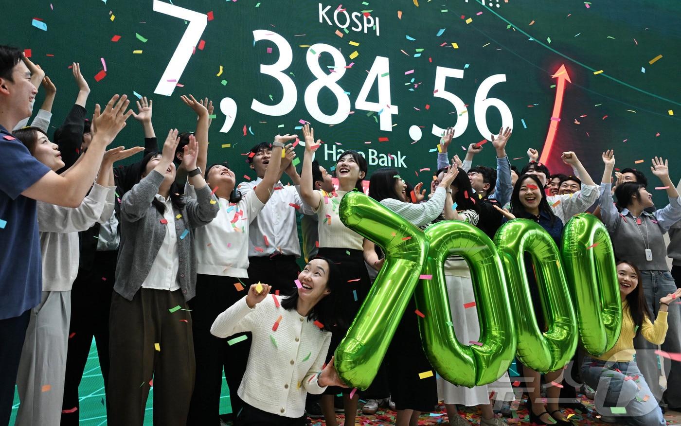 본문 이미지 - 코스피가 종가 기준 사상 처음 7000선을 돌파한 6일 서울 중구 하나은행 딜링룸에서 직원들이 축하 세레머니를 하고 있다. 이날 코스피는 전장보다 447.57포인트(6.45%) 오른 7,384.56에 장을 마쳤다. (공동취재) 2026.5.6 ⓒ 뉴스1 박지혜 기자