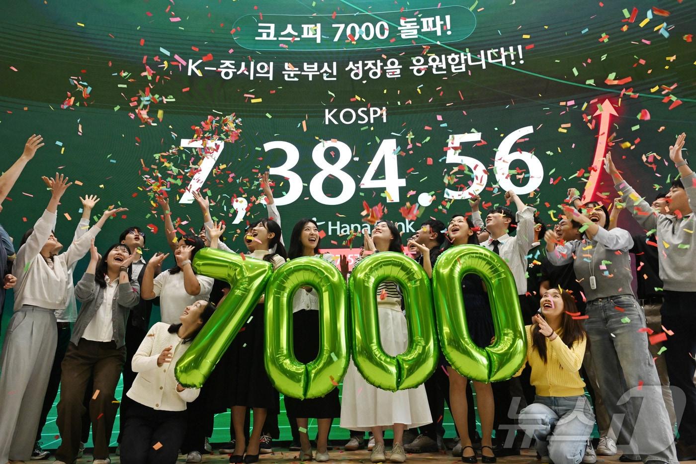 본문 이미지 - 코스피가 종가 기준 사상 처음 7000선을 돌파한 6일 서울 중구 하나은행 딜링룸에서 직원들이 축하 세레머니를 하고 있다. 이날 코스피는 전장보다 447.57포인트(6.45%) 오른 7,384.56에 장을 마쳤다. (공동취재) 2026.5.6 ⓒ 뉴스1 박지혜 기자