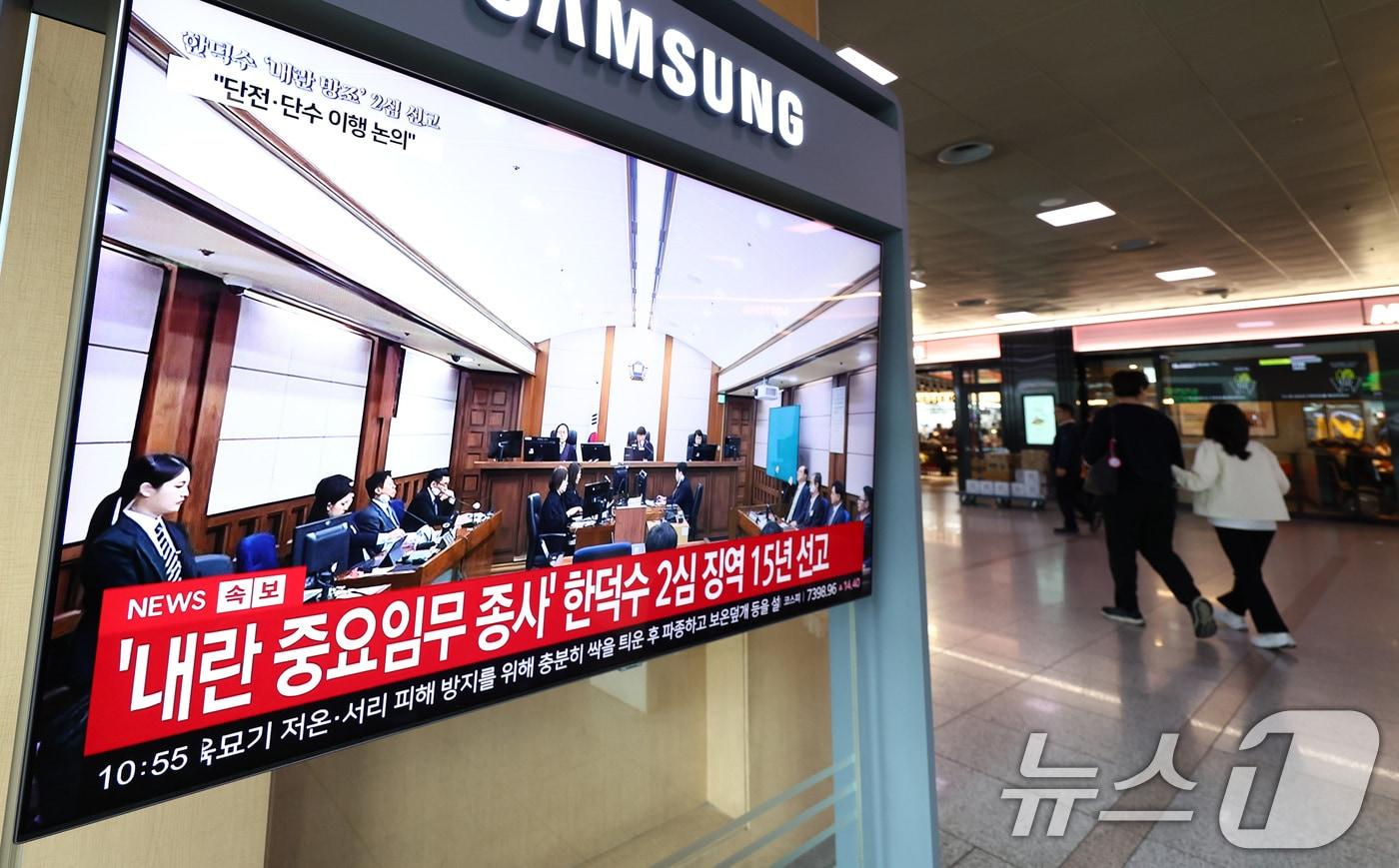 본문 이미지 - 7일 오전 서울 용산구 서울역 대합실에서 시민들이 12.3 비상계엄 사태와 관련해 내란 중요임무 종사 혐의를 받는 한덕수 전 국무총리의 항소심 선고 공판 관련 뉴스를 지켜보고 있다. 한 전 총리는 지난 1심 징역 23년 보다 8년 낮은 징역 15년형을 선고 받았다. 2026.5.7 ⓒ 뉴스1 최지환 기자