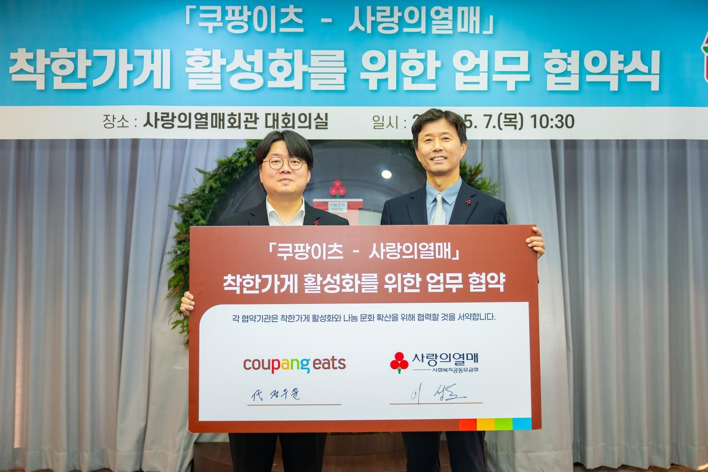 본문 이미지 -  정우윤 쿠팡이츠서비스 대외정책실장(왼쪽)과 이성도 사랑의열매 모금사업본부장이 업무협약을 기념하고 있다.(쿠팡이츠 제공).