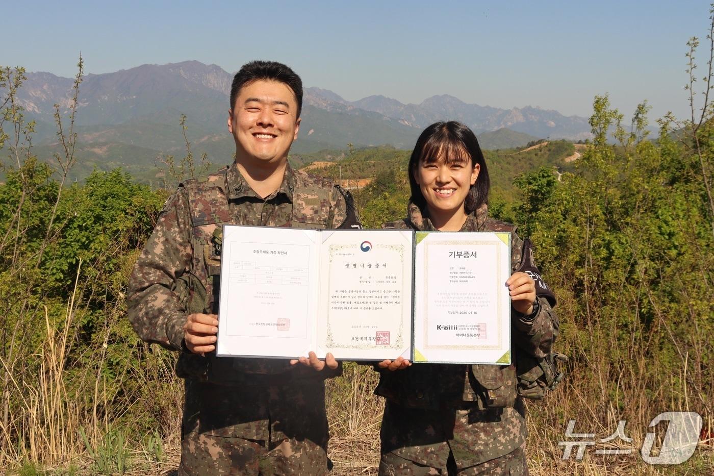 본문 이미지 - 육군 제22보병사단 문준표 상사와 구지은 중사가 임무수행 중인 일반전초(GOP)에서 조혈모세포와 모발 기증서를 펼치고 있다.(부대 측 제공, 재판매 및 DB 금지) 2026.5.7/뉴스1