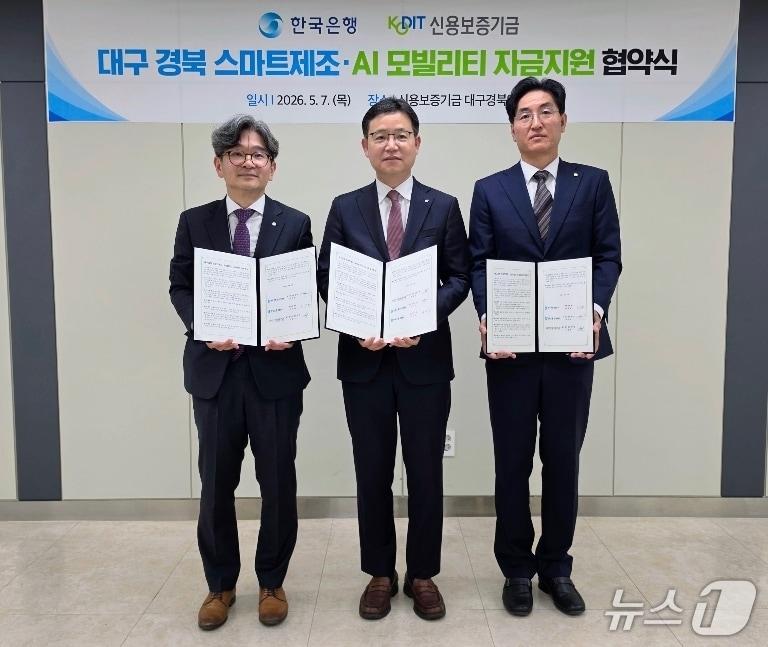 본문 이미지 - 김주현 한국은행 대구경북본부장(왼쪽)과 손용호 신용보증기금 대구경북영업본부장(가운데), 이덕배 한국은행 포항본부장이 스마트 제조·AI 모빌리티 자금 지원을 위한 업무협약을 체결한 뒤 협약서를 펼쳐 보이고 있다.(한은 대구경북본부 제공, 재판매 및 DB 금지)