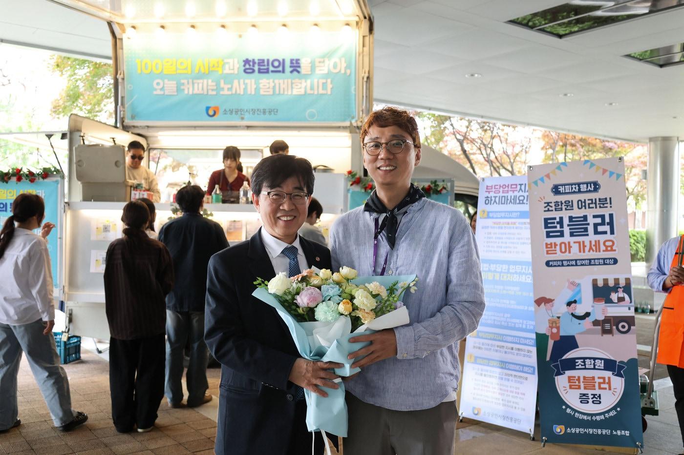 본문 이미지 - 취임 100일을 맞은 인태연 소진공 이사장(왼쪽)이  꽃다발을 받고 포즈를 취하고 있다. (소진공 제공)