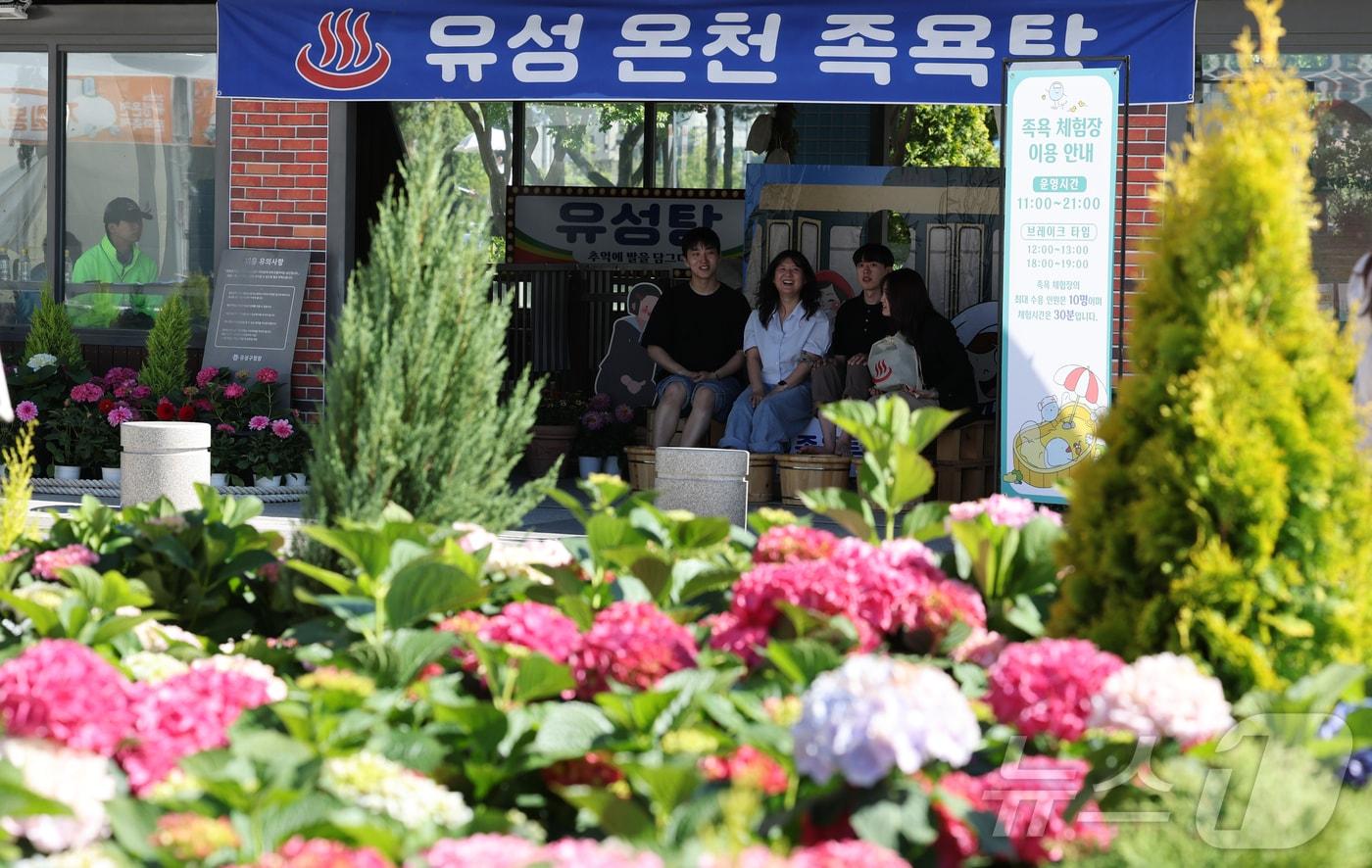 본문 이미지 - 8일 대전 유성구 유림공원 일원에서 열린 유성온천문화축제 족욕체험관을 찾은 시민들이 족욕을 즐기고 있다. 유성온천문화축제는 8~10일 '마음 치유'를 주제로 온천수 족욕 체험과 온천향기 치유 미니돔, 온천 향낭 만들기 등 힐링형 콘텐츠를 선보인다. ⓒ 뉴스1 김기태 기자