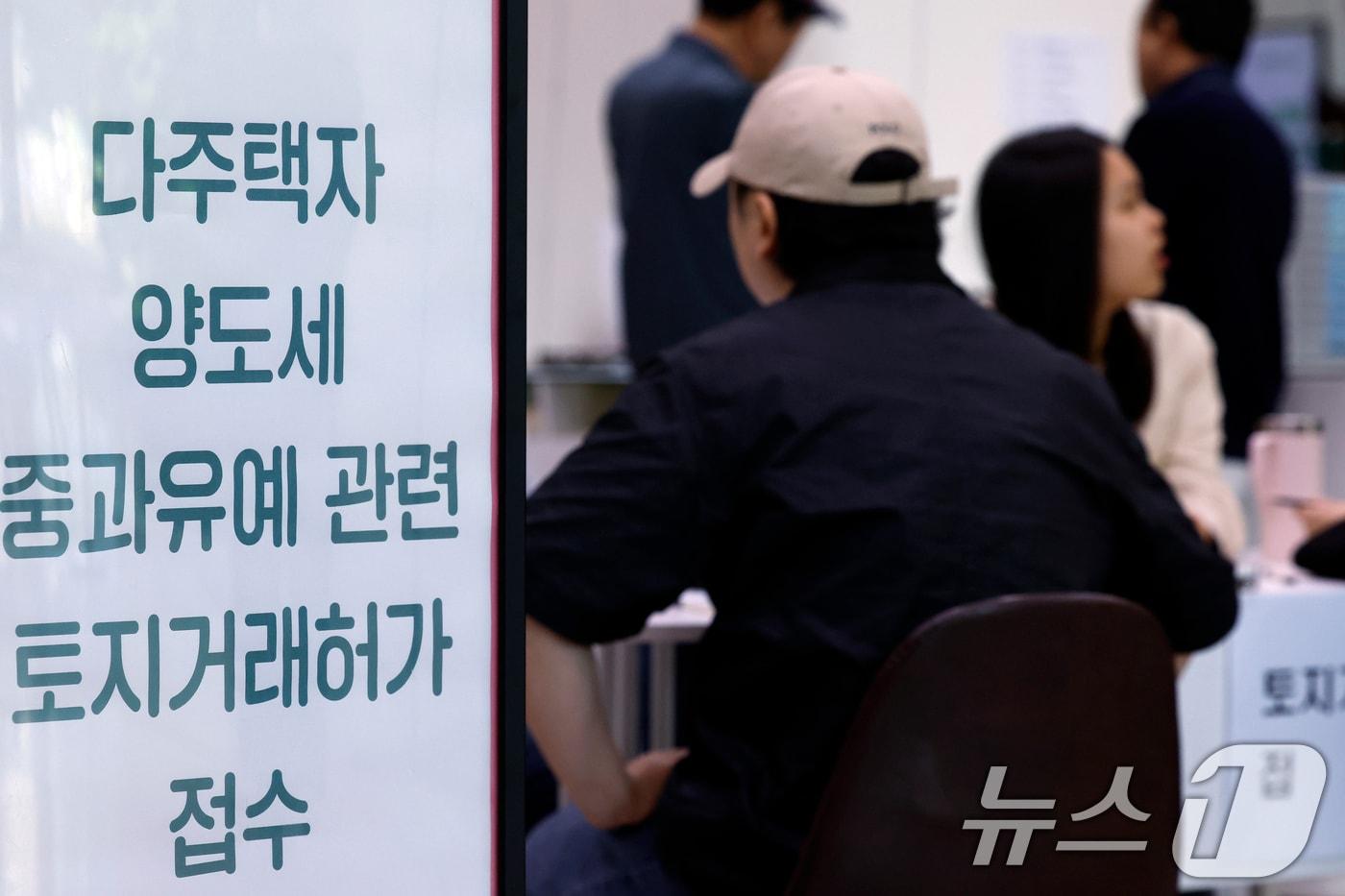 본문 이미지 - 다주택자 양도소득세 중과 유예 종료 시한인 9일 오전 서울시 송파구 송파구청 1층에 마련된 다주택자 양도세 중과유예 관련 토지거래허가 접수처를 찾은 시민들이 부동산정보과 공무원들에게 서류 검토를 받고 있다. ⓒ 뉴스1 박정호 기자