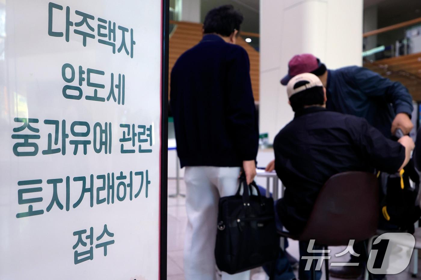 본문 이미지 - 9일 오전 서울시 송파구 송파구청 1층에 마련된 다주택자 양도세 중과유예 관련 토지거래허가 접수처를 찾은 시민들이 부동산정보과 공무원들에게 서류 검토를 받고 있다. 2026.5.9 ⓒ 뉴스1 박정호 기자