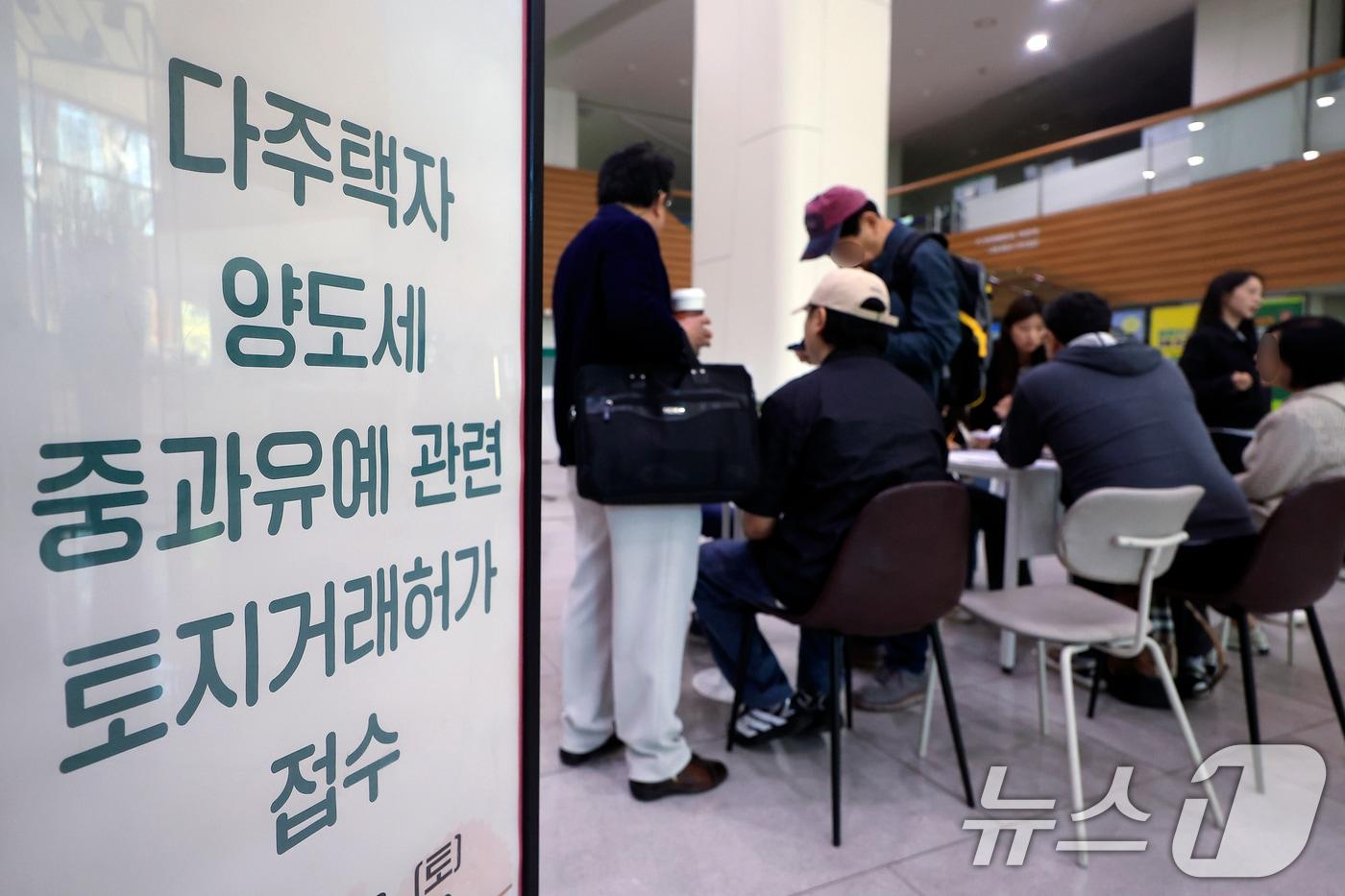 본문 이미지 - 다주택자 양도소득세 중과 유예 종료 시한인 9일 오전 서울시 송파구 송파구청 1층에 마련된 다주택자 양도세 중과유예 관련 토지거래허가 접수처를 찾은 시민들이 부동산정보과 공무원들에게 서류 검토를 받고 있다. 2026.5.9 ⓒ 뉴스1 박정호 기자