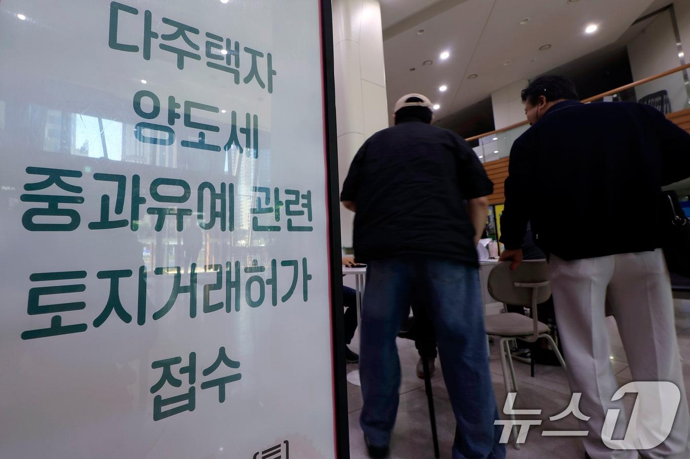 본문 이미지 - 다주택자 양도소득세 중과 유예 종료 시한인 9일 오전 서울시 송파구 송파구청 1층에 마련된 다주택자 양도세 중과유예 관련 토지거래허가 접수처를 찾은 시민들이 부동산정보과 공무원들에게 서류 검토를 받고 있다. 2026.5.9 ⓒ 뉴스1 박정호 기자