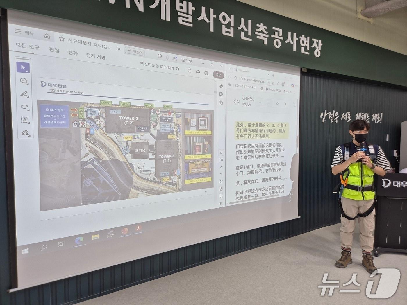 본문 이미지 - 대우건설 관계자가 과천 G-TOWN 개발사업 신축공사 현장에서 외국인 근로자를 위한 AI 번역기 기능에 대해 교육 중이다.(대우건설 제공) 