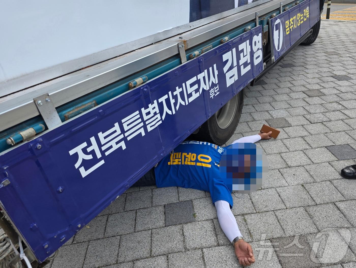 본문 이미지 - 1일 오전 8시 30분께 전북 전주시 효자동의 한 사거리에서 무소속 김관영 전북지사 후보 유세차 밑에 이원택 후보 선거운동원이 드러누운 모습.(독자 제공. 재판매 및 DB 금지) 2026.6.1 ⓒ 뉴스1 장수인 기자