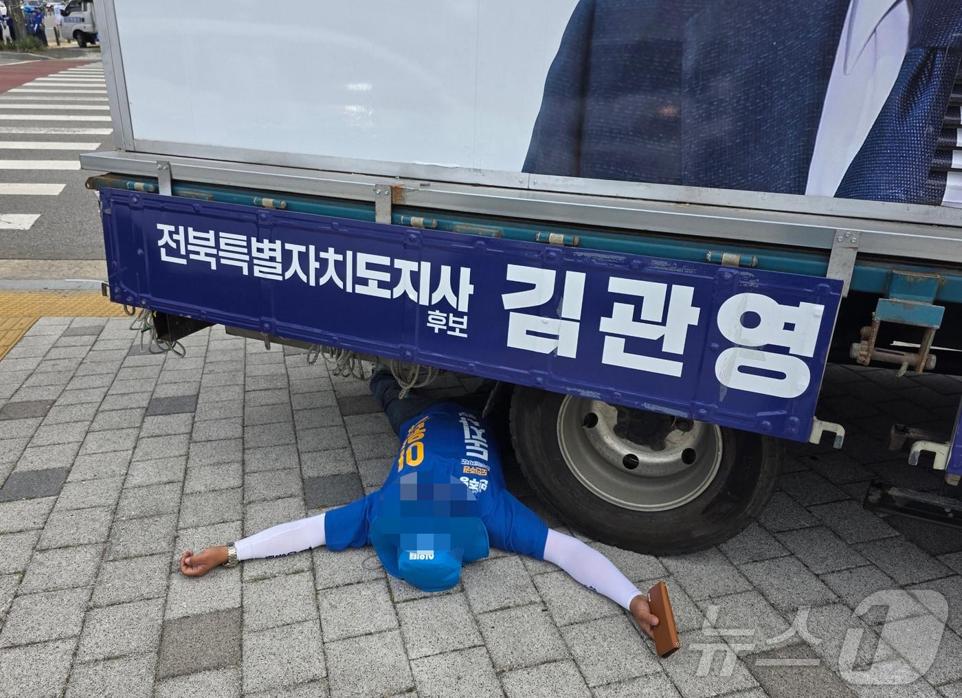본문 이미지 - 1일 오전 8시 30분께 전북 전주시 효자동의 한 사거리에서 무소속 김관영 전북지사 후보 유세차 밑에 이원택 후보 선거운동원이 드러누운 모습.(독자 제공. 재판매 및 DB 금지) 2026.6.1 ⓒ 뉴스1 장수인 기자
