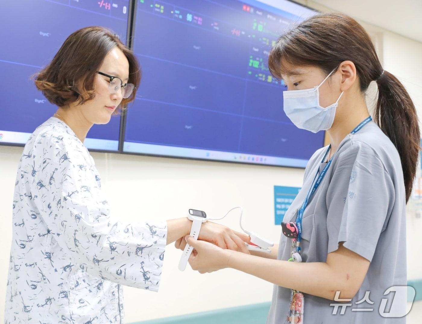 본문 이미지 - 강릉아산병원 스마트 케어 병동에 입원한 환자가 AI 환자감시 시스템과 연동되는 웨어러블 기기를 착용하고 있다.(강릉아산병원 제공, 재판매 및 DB 금지) 2026.6.1/뉴스1