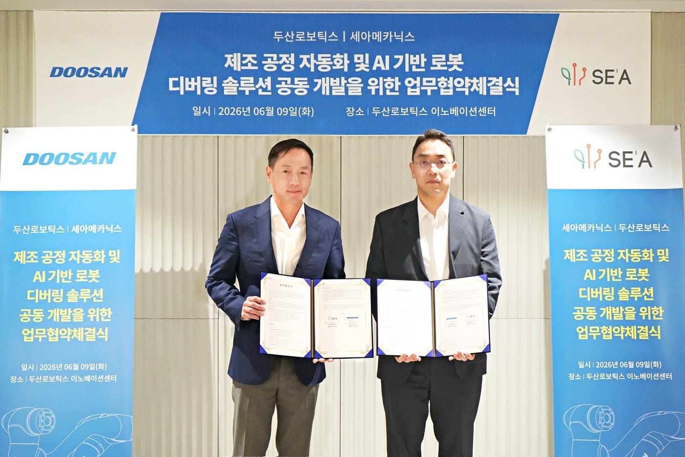 본문 이미지 - 박인원 두산로보틱스 대표(왼쪽)가 이성욱 세아메카닉스 대표와 업무협약식 후 기념사진을 촬영하고 있다.(두산로보틱스 제공)/뉴스1