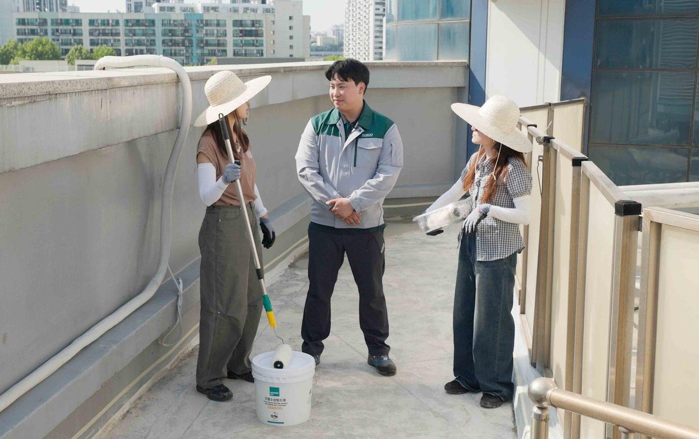 본문 이미지 - 차열 수성 방수페인트 담당자가 반포종합사회복지관 옥상에서 시공 방법을 설명하고 있다.(노루페인트 제공)