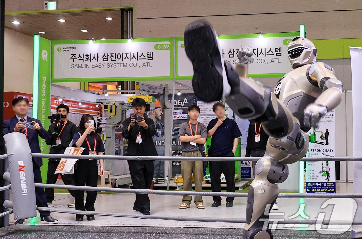 본문 이미지 - 10일 서울 강남구 코엑스에서 열리는 ‘2026 스마트테크 코리아'를 찾은 관람객들이 휴머노이드 로봇 시연을 살펴보고 있다. 2026.6.10 ⓒ 뉴스1 이호윤 기자