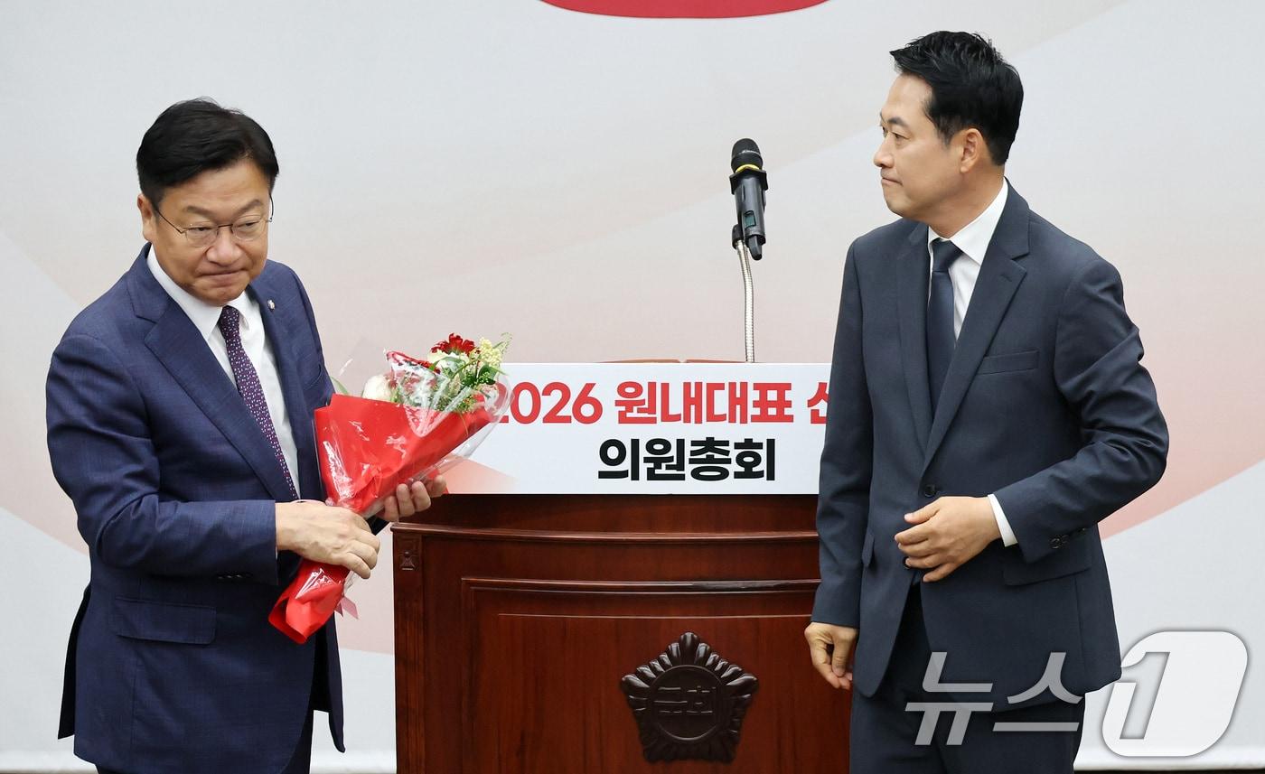 본문 이미지 - 장동혁 국민의힘 대표가 10일 서울 여의도 국회에서 열린 국민의힘 원내대표 선출 의원총회에서 정점식 신임 원내대표에게 꽃다발을 전달하고 있다. (공동취재) 2026.6.10 ⓒ 뉴스1 신웅수 기자