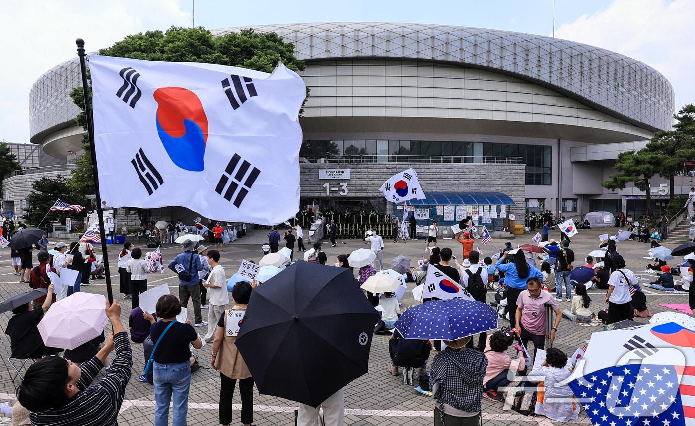 본문 이미지 - 제9회 전국동시지방선거 투표용지 부족 사태를 규탄하며 재선거를 요구하는 집회가 계속되는 10일 서울 송파구 올림픽공원 핸드볼경기장 개표소 앞에 시민들이 모여 재선거를 요구하는 구호를 외치고 있다. 2026.6.10 ⓒ 뉴스1 이호윤 기자