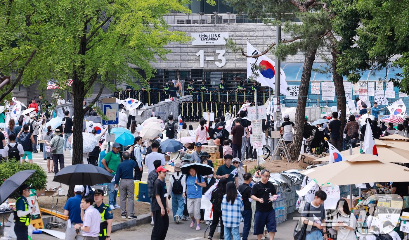 본문 이미지 - 제9회 전국동시지방선거 투표용지 부족 사태를 규탄하며 재선거를 요구하는 집회가 계속되는 10일 서울 송파구 올림픽공원 핸드볼경기장 개표소 앞에 시민들이 모여 재선거를 요구하는 구호를 외치고 있다. 2026.6.10 ⓒ 뉴스1 이호윤 기자