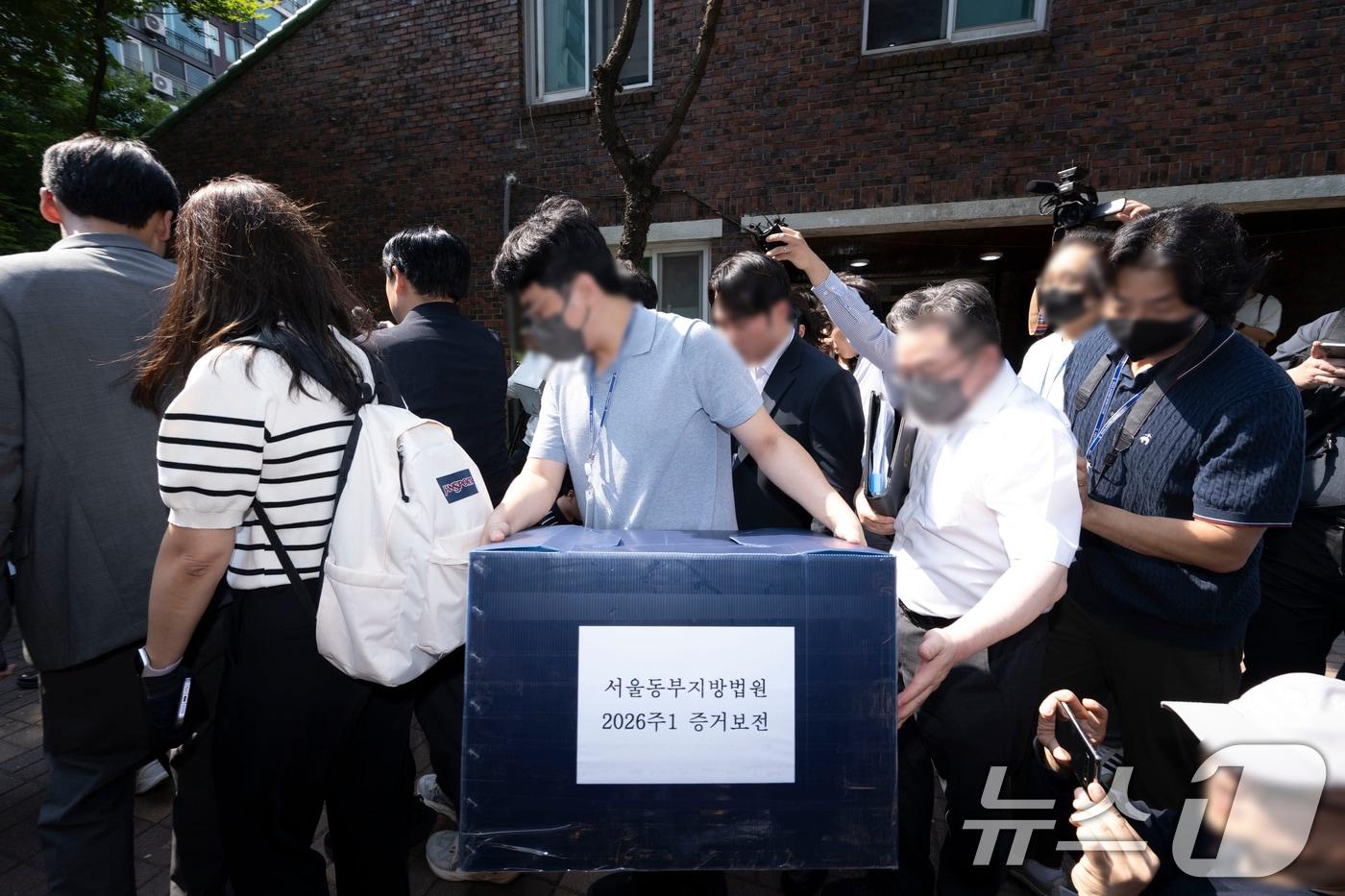 본문 이미지 - 김지연 서울동부지방법원 부장판사와 관계자들이 10일 오후 6·3 지방선거 투표용지 부족 사태가 발생한 잠실7동 제2투표소였던 서울 송파구 우성아파트 노인정의 현장 검증을 마친 뒤 증거물을 들고 차량으로 향하고 있다. (공동취재) 2026.6.10 ⓒ 뉴스1 최지환 기자