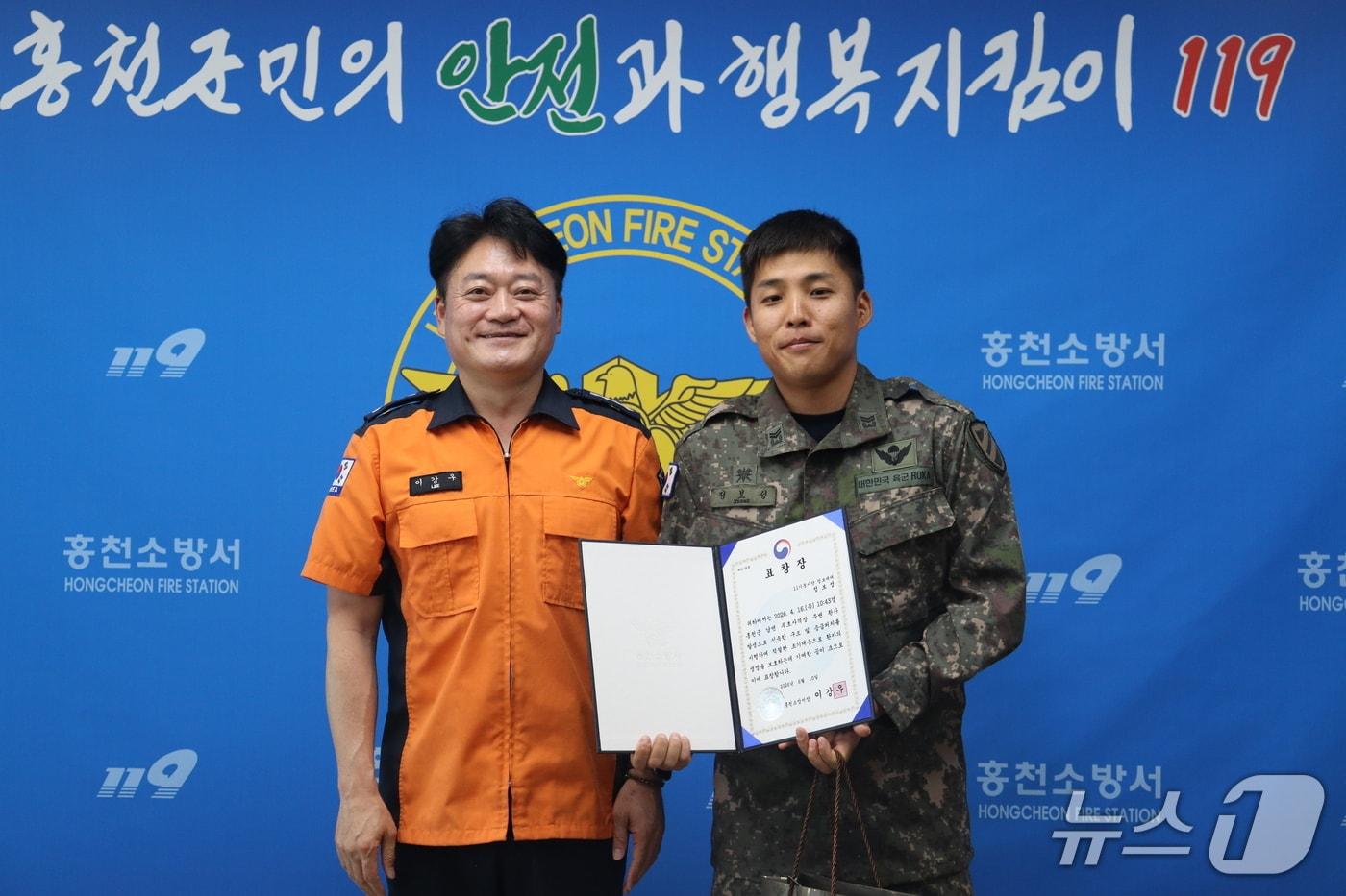 본문 이미지 - 육군제11기동사단 예하 정보중대 소속 정보성 중사(사진 오른쪽)가 시민을 구한 공로로 홍천소방서장 표창을 받고 있다.(육군제11기동사단 제공. 재판매 및 DB금지)/뉴스1