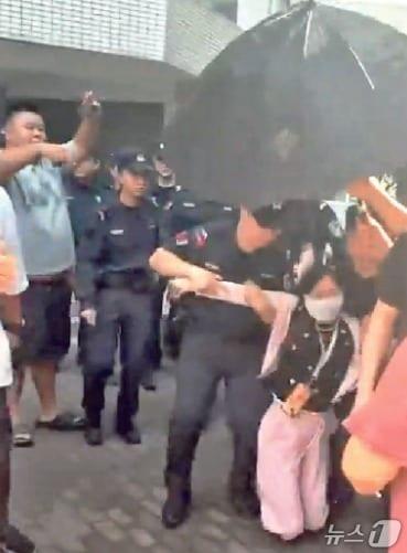 본문 이미지 - 경찰이 충칭 동물학대범 처벌을 주장하는 시위대를 제지하고 있다. (명보 갈무리)