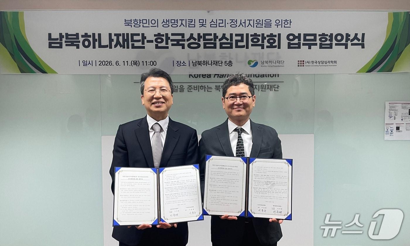 본문 이미지 - 남북하나재단 이주태 이사장 직무대행(왼쪽)과 한국상담심리학회 이동훈 학회장(오른쪽)이 11일 서울 마포구 재단 이사회의실에서 열린 업무협약 체결식에서 기념촬영을 하고 있다.(남북하나재단 제공).