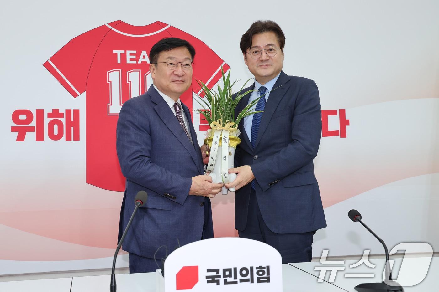 본문 이미지 - 정점식 국민의힘 원내대표(왼쪽)가 11일 오후 서울 여의도 국회에서 홍익표 대통령비서실 정무수석으로부터 이재명 대통령 명의 축하 난을 받고 있다. 2026.6.11 ⓒ 뉴스1 안은나 기자