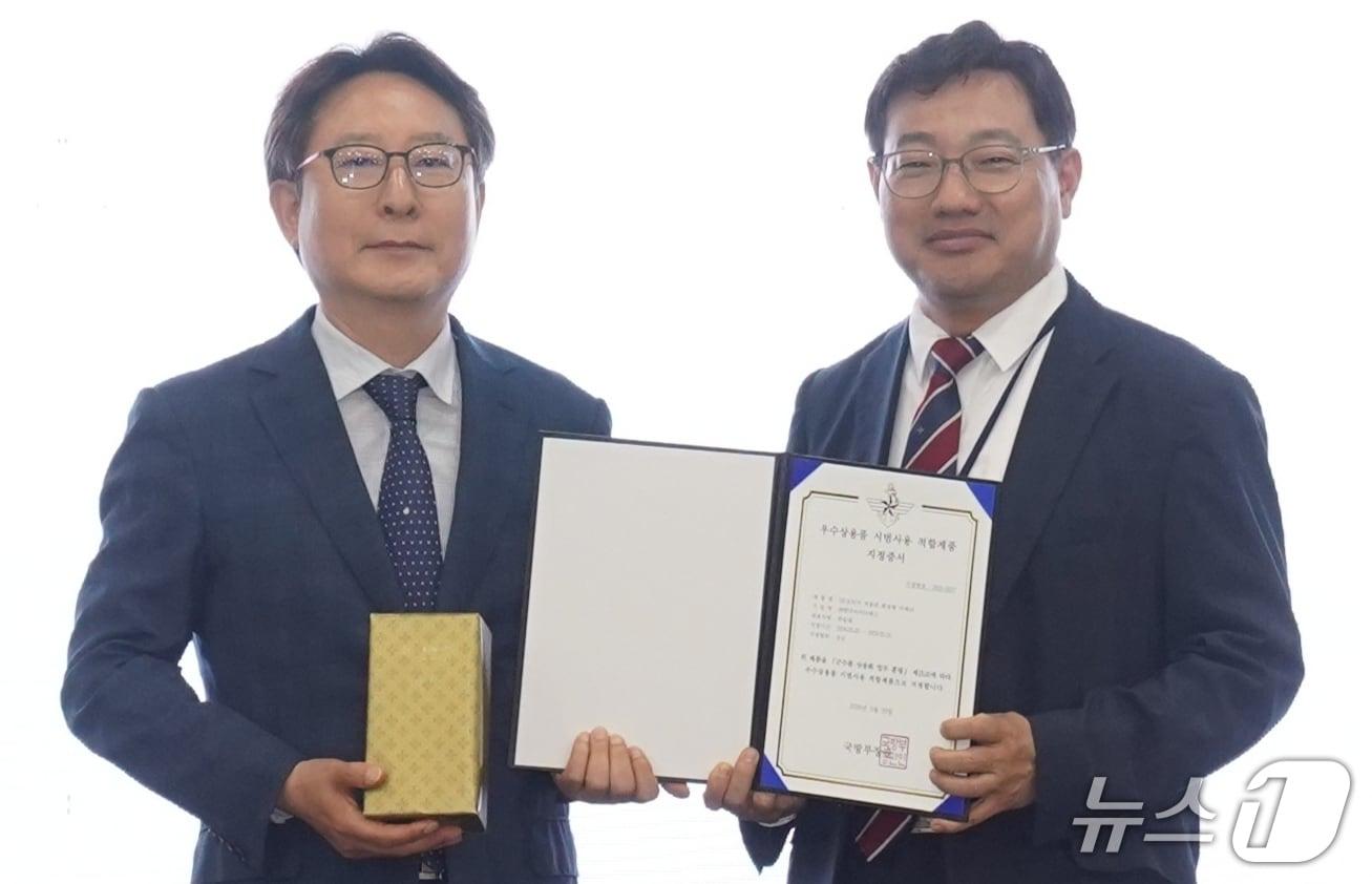 본문 이미지 - 하승태 한국 아이티에스 대표가 국방부 '우수상용품 시범사용 적합제품' 지정서를 받은 뒤 기념사진을 찍고 있다.