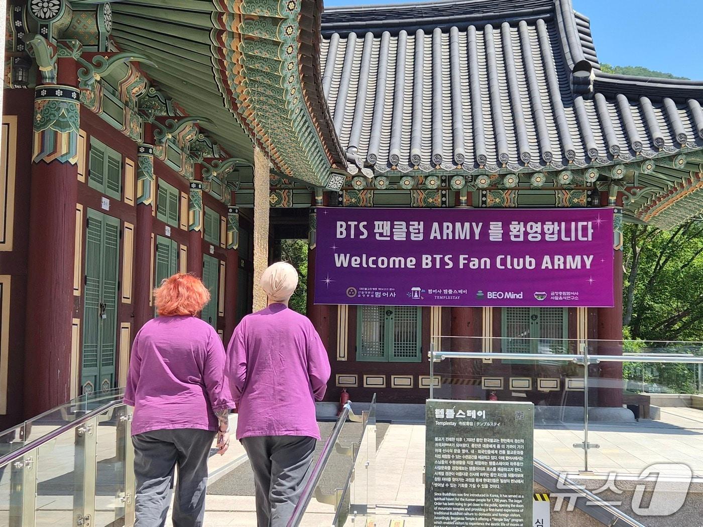 본문 이미지 - BTS 공연을 맞아 사찰을 방문한 팬들이 BTS의 상징색인 보라색 옷을 입은 두 명의 아미(ARMY)가 12일 오전 산책을 마치고 숙소로 들어서고 있다. 2026.6.12/뉴스1 ⓒ News1 임순택 기자