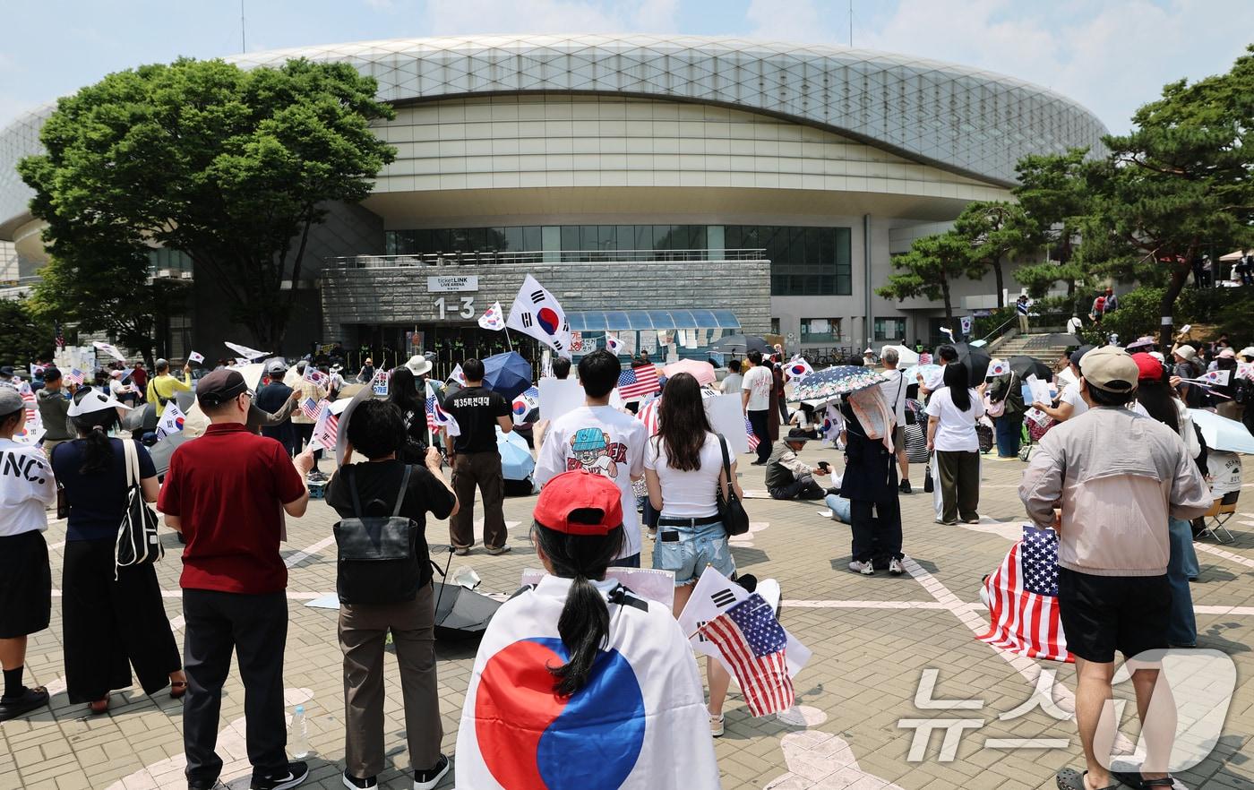 본문 이미지 - 제9회 전국동시지방선거 투표용지 부족 사태를 규탄하는 개표소 봉쇄 시위가 계속된 12일 서울 송파구 올림픽공원 핸드볼경기장 앞에서 시민들이 태극기를 흔들며 재선거를 요구하고 있다. 2026.6.12 ⓒ 뉴스1 오대일 기자