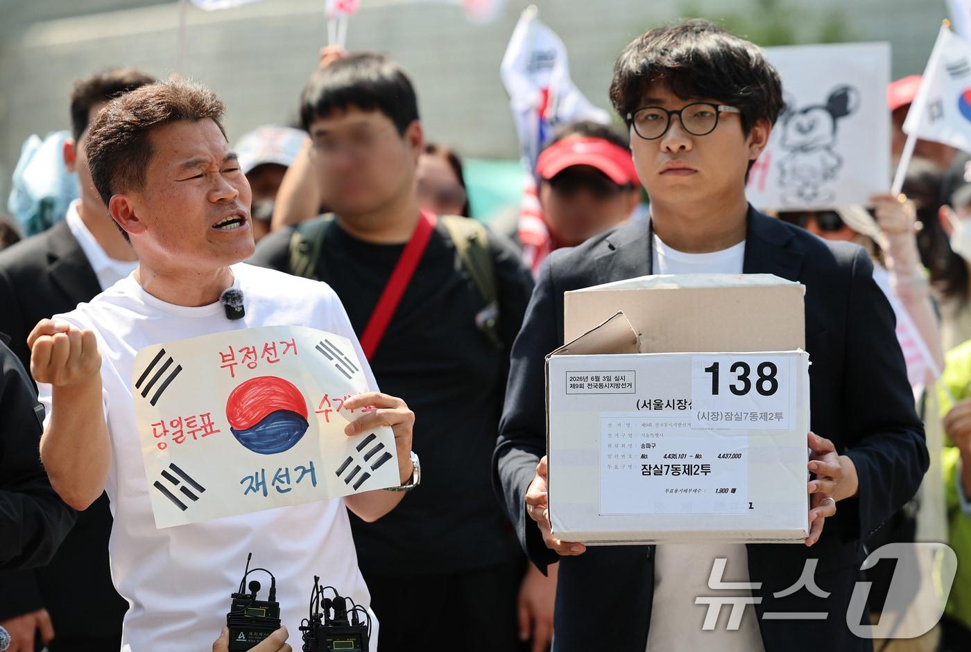 본문 이미지 - 한국사 강사 출신 유튜버 전한길 씨가 12일 오후 서울 송파구 올림픽공원 핸드볼경기장에서 긴급 기자회견을 열고 선거관리위원회가 폐기했다고 밝힌 잠실7동 제2투표소 투표용지 보관상자 추정 물품을 공개하고 있다. 2026.6.12 ⓒ 뉴스1 오대일 기자