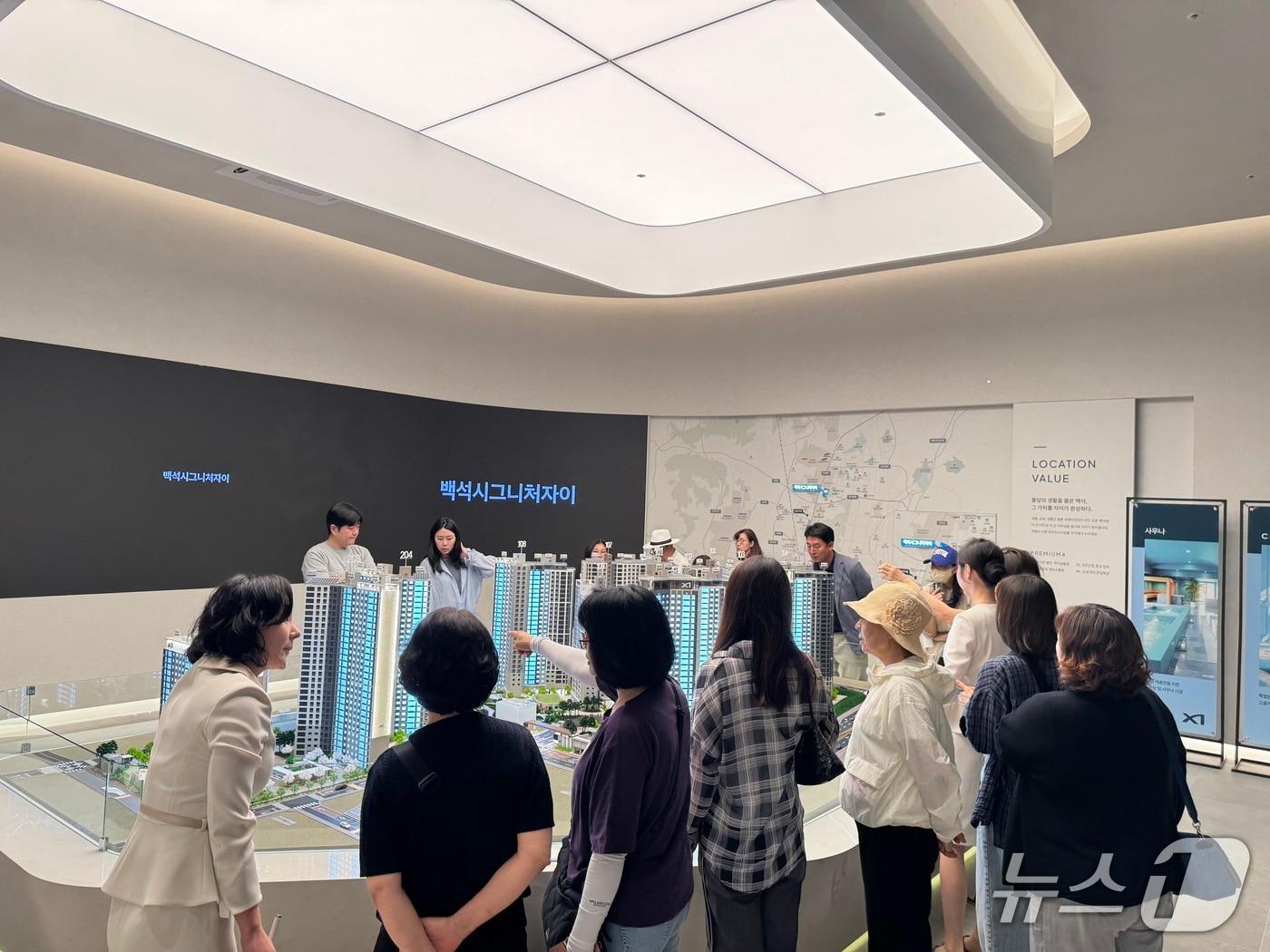 본문 이미지 - 12일 오전 충남 천안 서북구 '백석시그니처자이' 견본주택 내부에서 방문객들이 단지 모형도를 관찰하고 있다. 2026.6.12 ⓒ 뉴스1 윤주현 기자